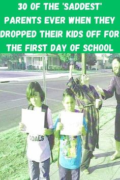 two children holding up signs on the sidewalk with an adult and child standing next to them