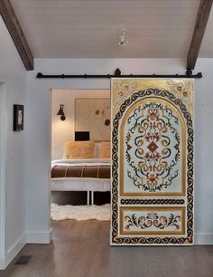 an open door leading to a bedroom with a bed in the background and a rug on the floor