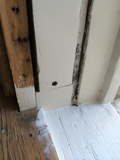 an open door with peeling paint on the side and wood flooring around it's edges