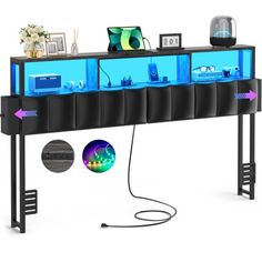 a computer desk with an aquarium on top and various electronics in the back, along with other items