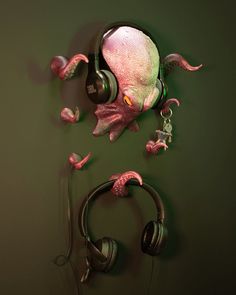 an octopus with headphones hanging from it's back on the wall next to a pair of headphones