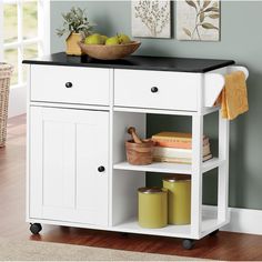 a white kitchen island with black top and drawers