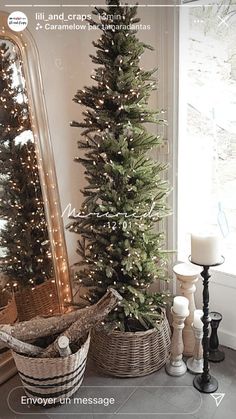 a small christmas tree in a basket next to a large mirror and candle on the floor