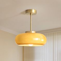 a yellow light hanging from the ceiling in a room