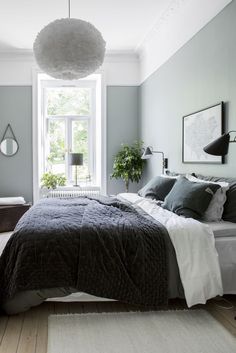 a bedroom with gray walls and white bedding