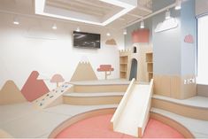 an indoor play area for children with slides and climbing walls in the shape of castles