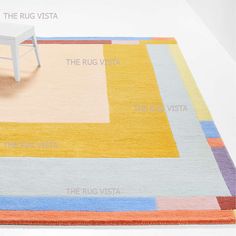 an area rug with different colors and sizes on the floor next to a white chair