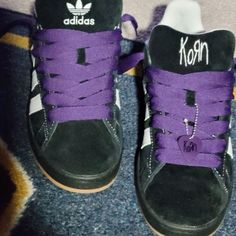 two shoes with purple and black laces on them