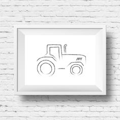 a drawing of a tractor on a white brick wall in front of a black and white frame