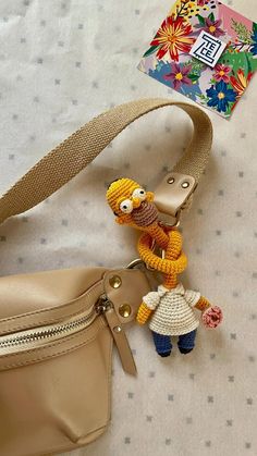 a cell phone strap that has a cartoon character on it and a small purse with a keychain attached to it