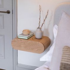 a bed with a white pillow and some books on it