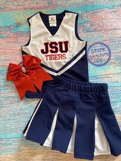 a cheerleader outfit with a red bow on the side and a matching skirt for girls