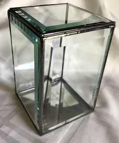 a glass box sitting on top of a white sheet