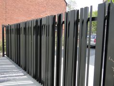 a black metal fence next to a brick building