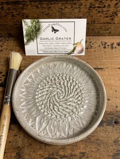 a white plate sitting on top of a wooden table next to a brush