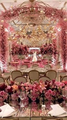 the tables are decorated with pink flowers and chandeliers