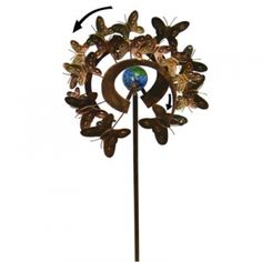 a metal sculpture with butterflies on it and a blue earth in the center is shown