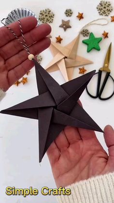 someone holding an origami star in their hand with scissors and other crafting supplies