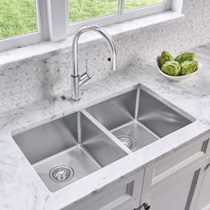 a kitchen with marble counter tops and stainless steel sinks