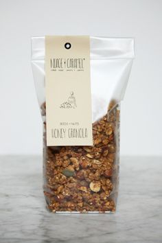 a bag of honey granola sitting on top of a marble counter next to a white wall