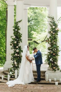 a bride and groom standing in front of an outdoor gazebo at their wedding ceremony