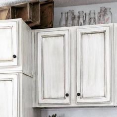 a kitchen with white cabinets and wooden drawers