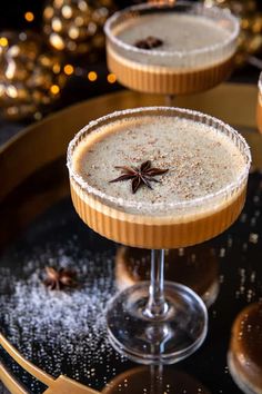 two martinis with anisette garnish on the rim and cinnamon stars