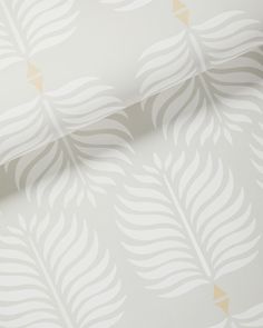 a white and gold wallpaper with leaves on it