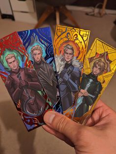 a hand holding four card game cards with the same character on each one and an image of them in different colors