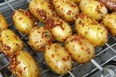 some potatoes are cooking on a grill with seasoning