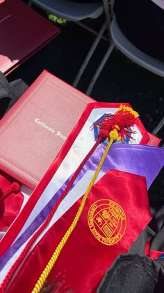 a red book sitting on top of a table next to some other books and papers