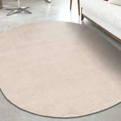 a living room with a white couch and round rug on the floor next to a coffee table