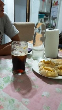 a person sitting at a table with some food and drinks on the table in front of them