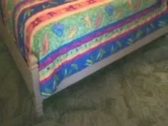 a bed with a colorful bedspread on top of it