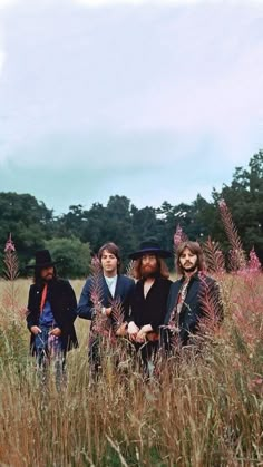 three people are sitting in the tall grass