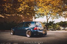 a blue car parked in front of some trees