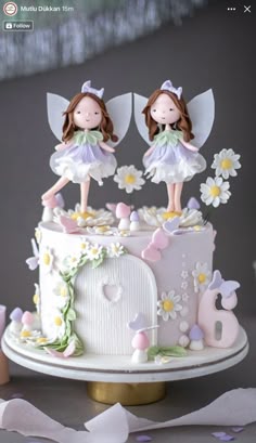 two little fairy figurines on top of a cake