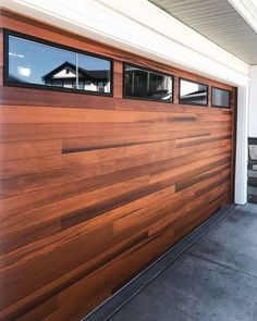 a wooden garage door with windows on the side