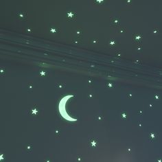 stars and moon glow in the night sky above a bedroom window with green walls,