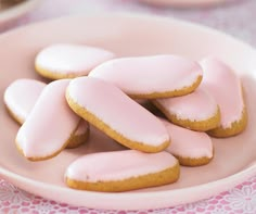 some pink cookies are on a white plate