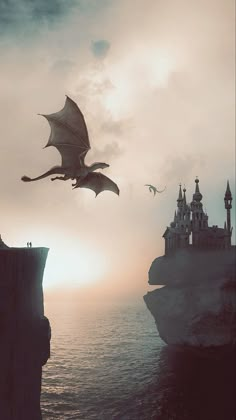 a large dragon flying over the ocean next to a castle on top of a cliff