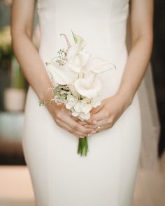 a woman in a white dress holding a bouquet of flowers