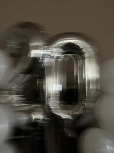 an abstract photograph of the number 10 in front of some white balloons with blurry background