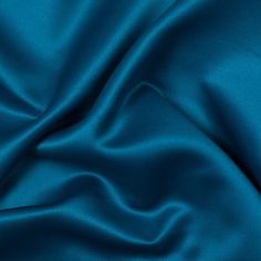 a close up view of a blue satin fabric with very soft folds and smooth lines