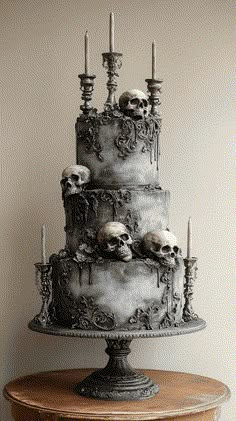 a three tiered cake with skulls on it and candles sticking out of the top