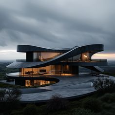 a modern house with an unusual design on top of a hill in the country side