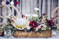 an arrangement of flowers in a wooden box