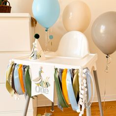 balloons and streamers are on display in the corner of a baby's room