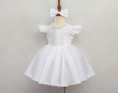 Dress your little one in our beautiful White Pearl Flower Girl Dress, complete with a soft, customizable color bow. This sweet ivory baby dress is made with soft tulle, making it perfect for your flower girl at any wedding or special occasion. The delicate design of this white flower girl dress adds a touch of elegance, while keeping your baby comfortable. Whether it's for a wedding or a big family event, your little girl will look absolutely adorable and feel special in this lovely dress. 🌻 Dr White Puffy Sleeve Dress, Ivory Dress Wedding, Puffy Sleeve Dress, Smash Cake Photoshoot, White Flower Girl Dresses, Ivory Dress, Dress Birthday, Kids Dresses, Light Ivory