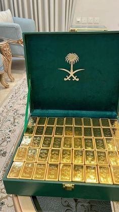 a green box filled with gold bars on top of a table